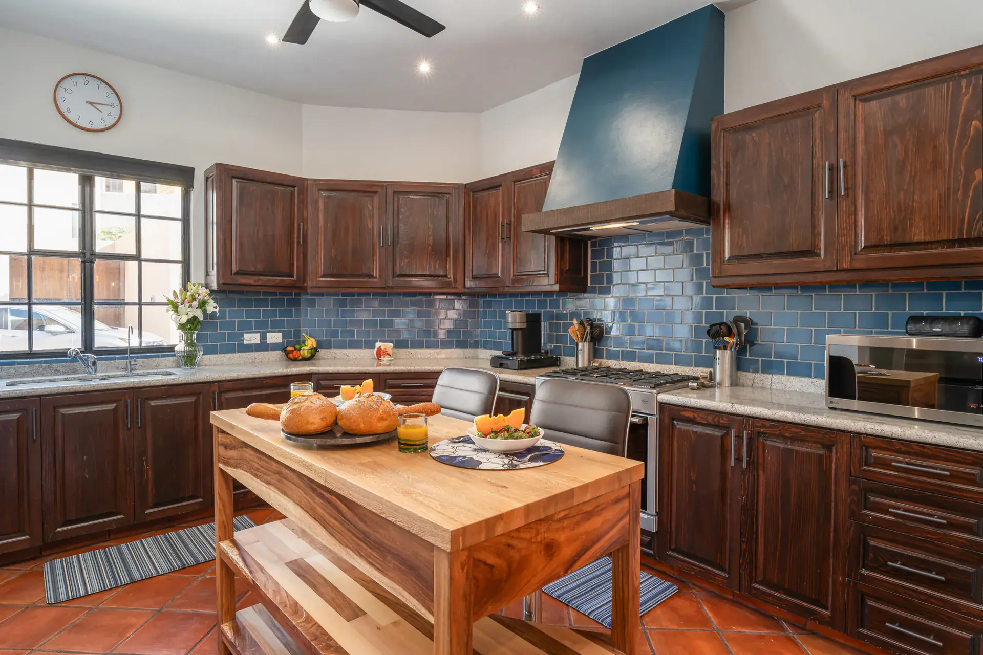 Villa Van Gogh, kitchen with dark wood cabinets, blue tile and a butcher-block island, San Miguel de Allende
