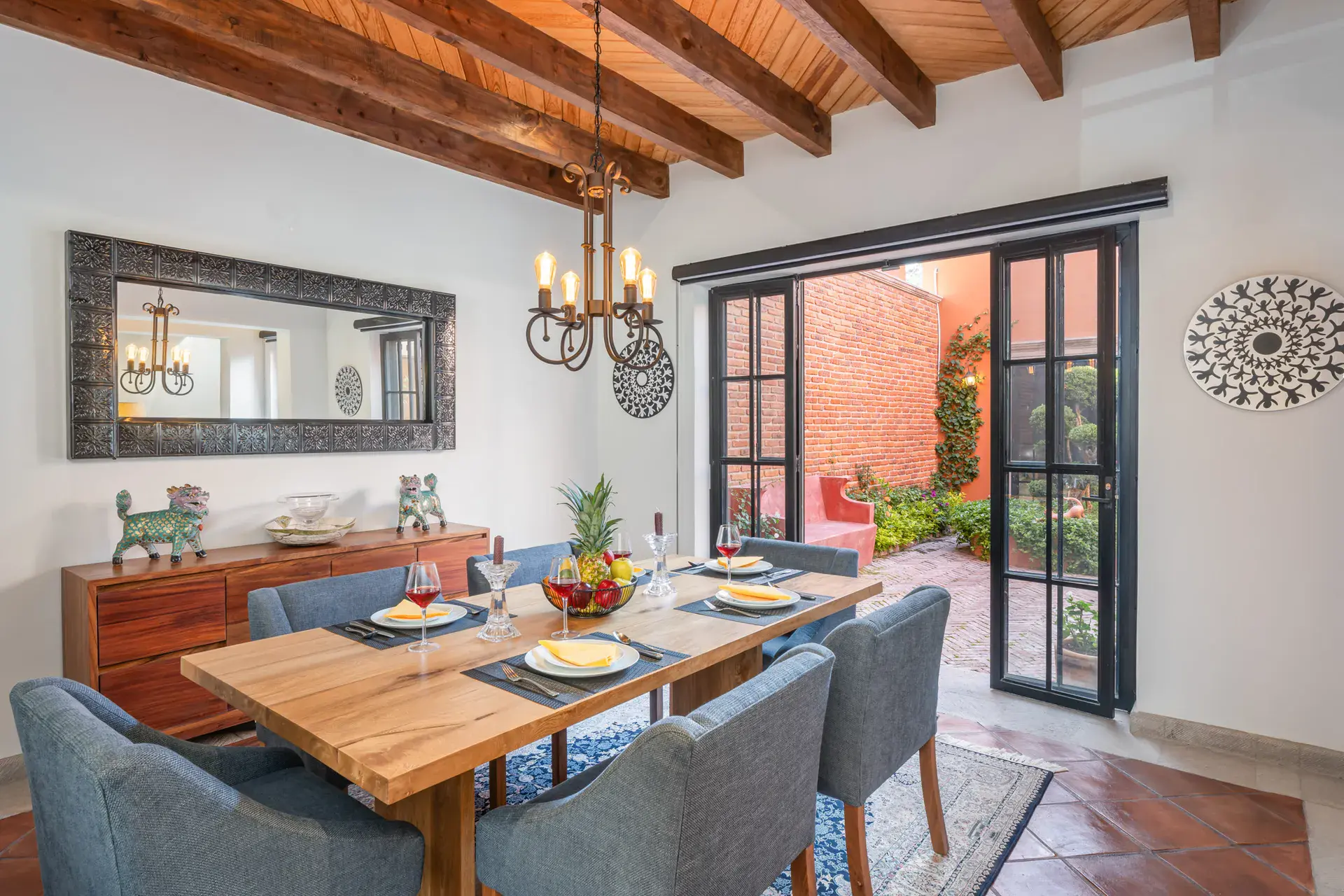Villa Van Gogh, dining room with a wood table and blue chairs under a beamed ceiling, San Miguel de Allende
