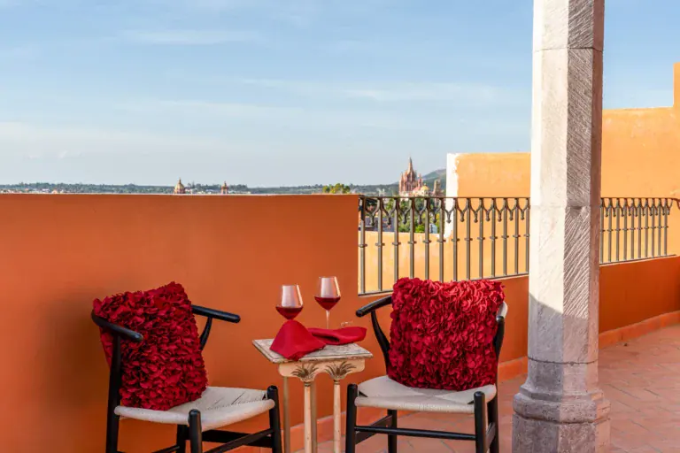 Villa Van Gogh, rooftop terrace with red chairs and a view of the Parroquia, San Miguel de Allende