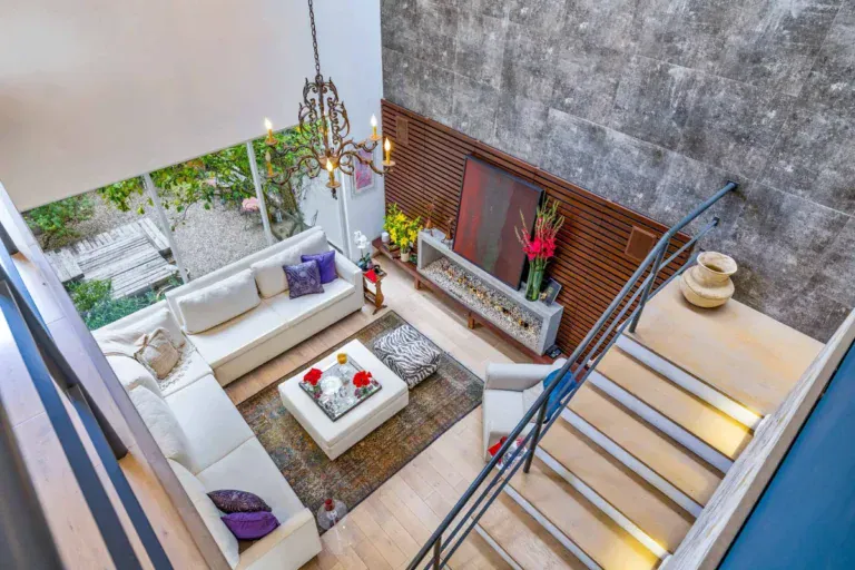 Sunken living area seen from the stairs, with a white sectional and stone feature wall, San Miguel de Allende